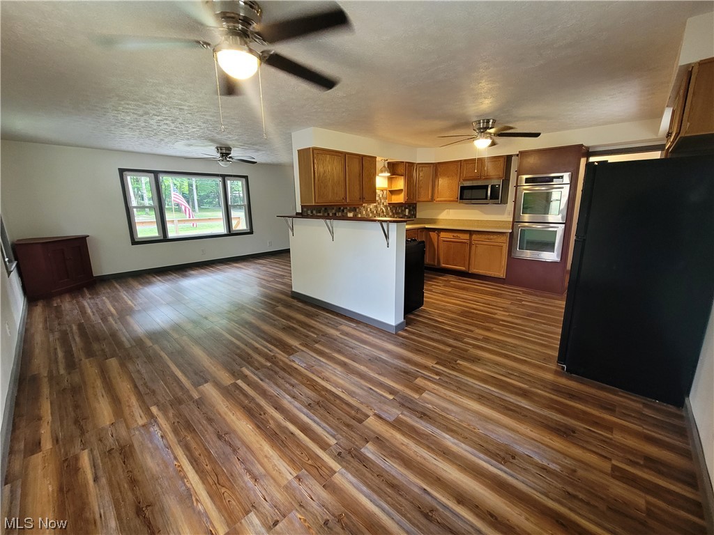 4166 Sherman Road Kent, OH 44240 - Photo 5 of 33 Kitchen featuring ceiling fan, stainless steel appliances, a kitchen breakfast bar, and dark hardwood floors