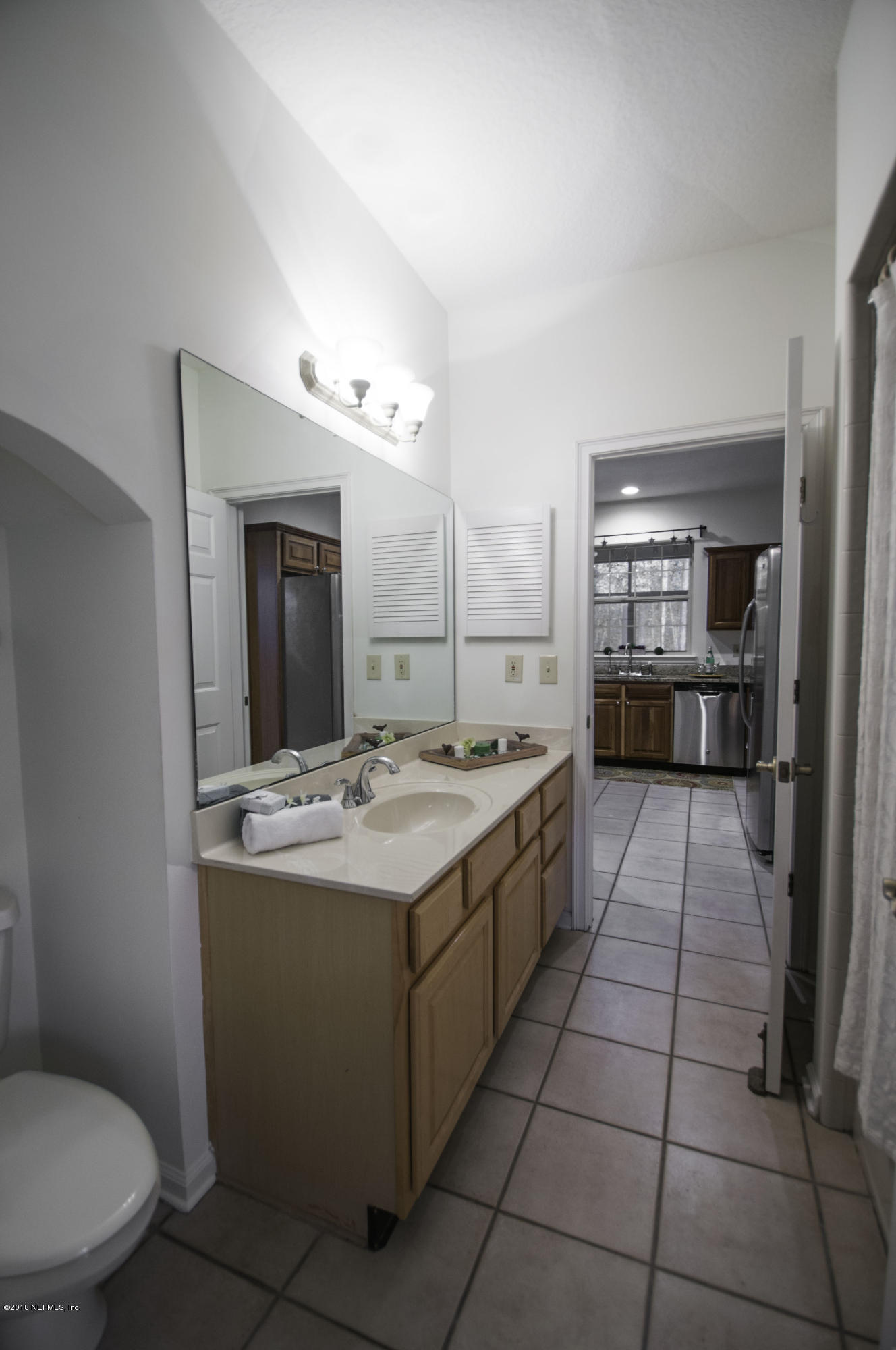 1341 Roberts Road St. Johns, FL 32259 - Photo 11 of 36 a large bathroom with a granite countertop sink a toilet a mirror and a bathtub