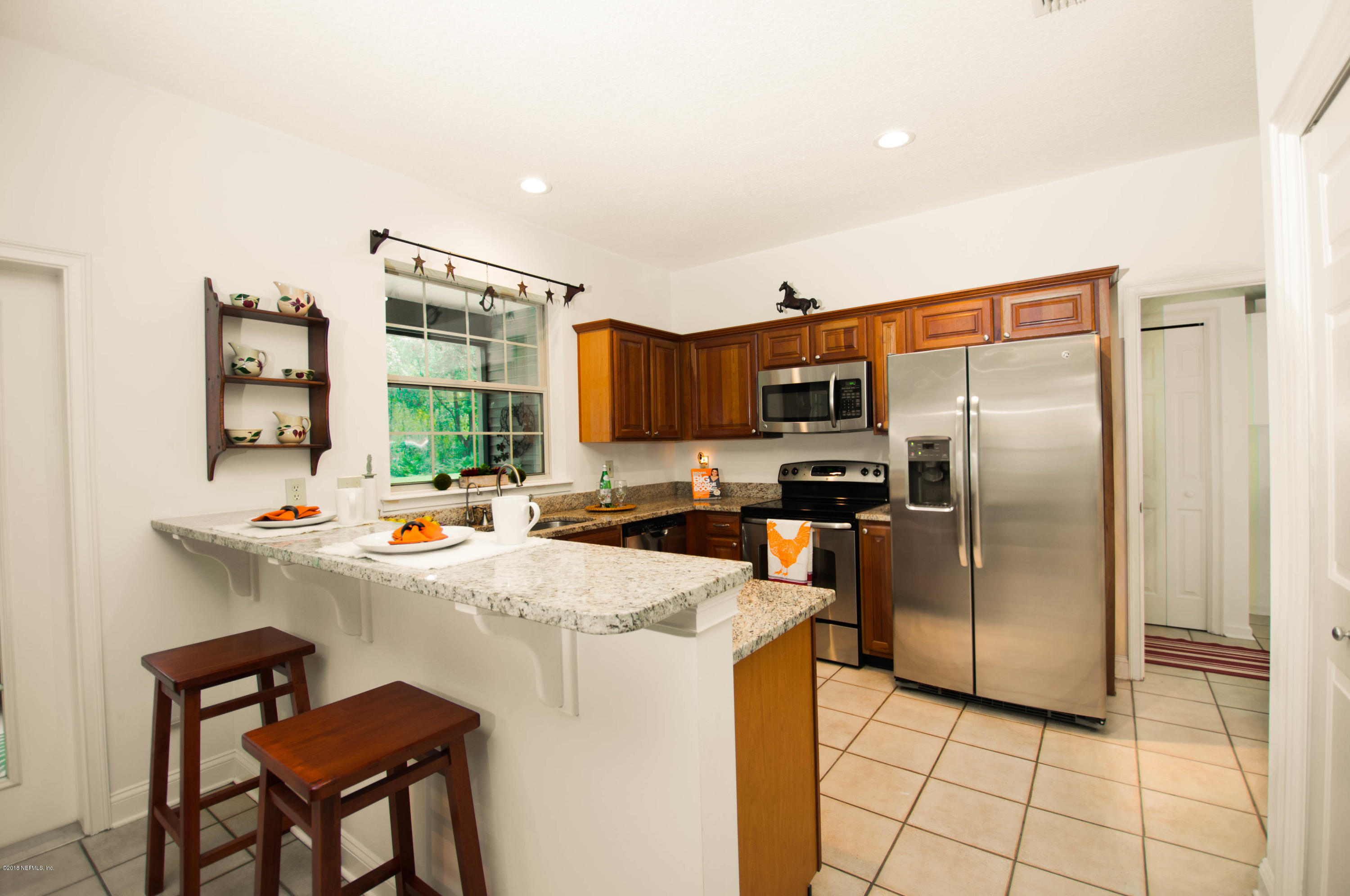 1341 Roberts Road St. Johns, FL 32259 - Photo 9 of 36 a kitchen with stainless steel appliances a stove top oven a refrigerator a sink a dining table and chairs
