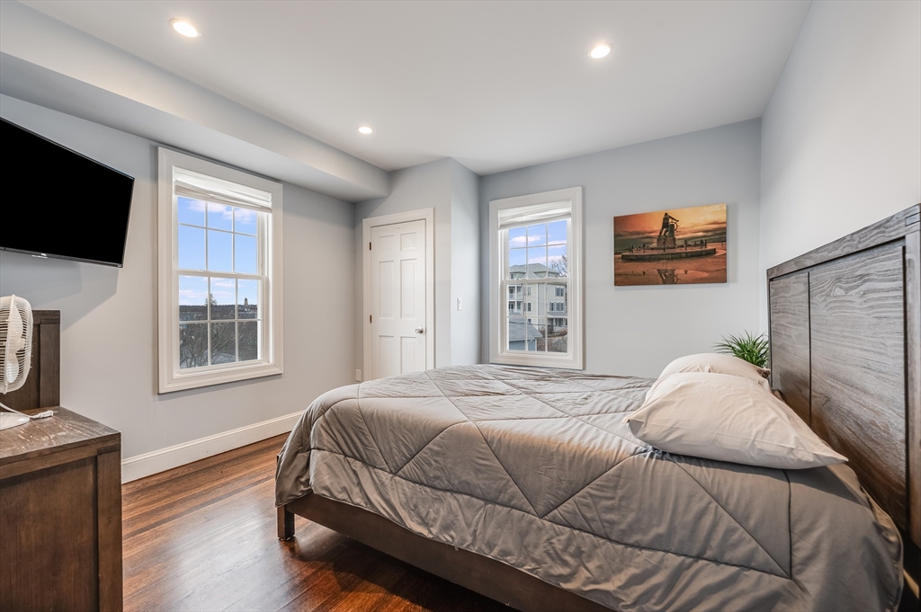 17 Silva Court, Unit 3 Gloucester, MA 01930 - Photo 18 of 22 a bedroom with a bed a tv and wooden floor