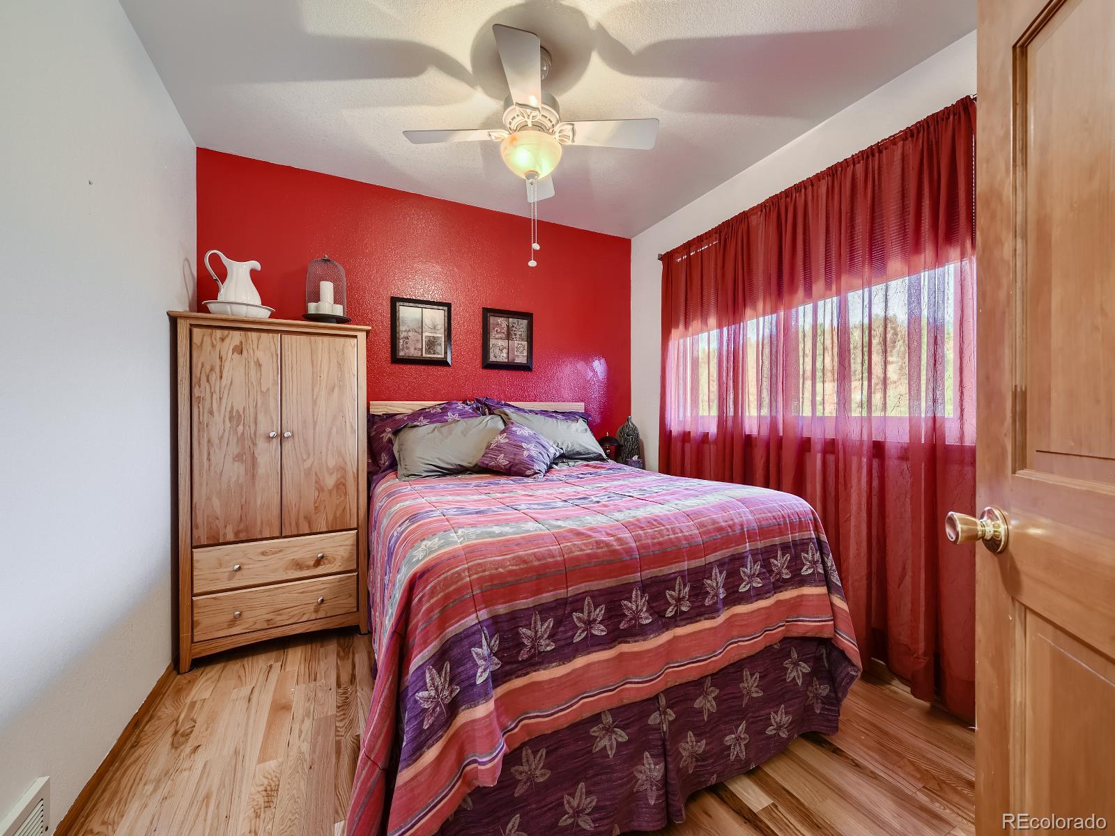 7051 Ski Trail Evergreen, CO 80439 - Photo 13 of 39 a bedroom with a large bed and a chandelier