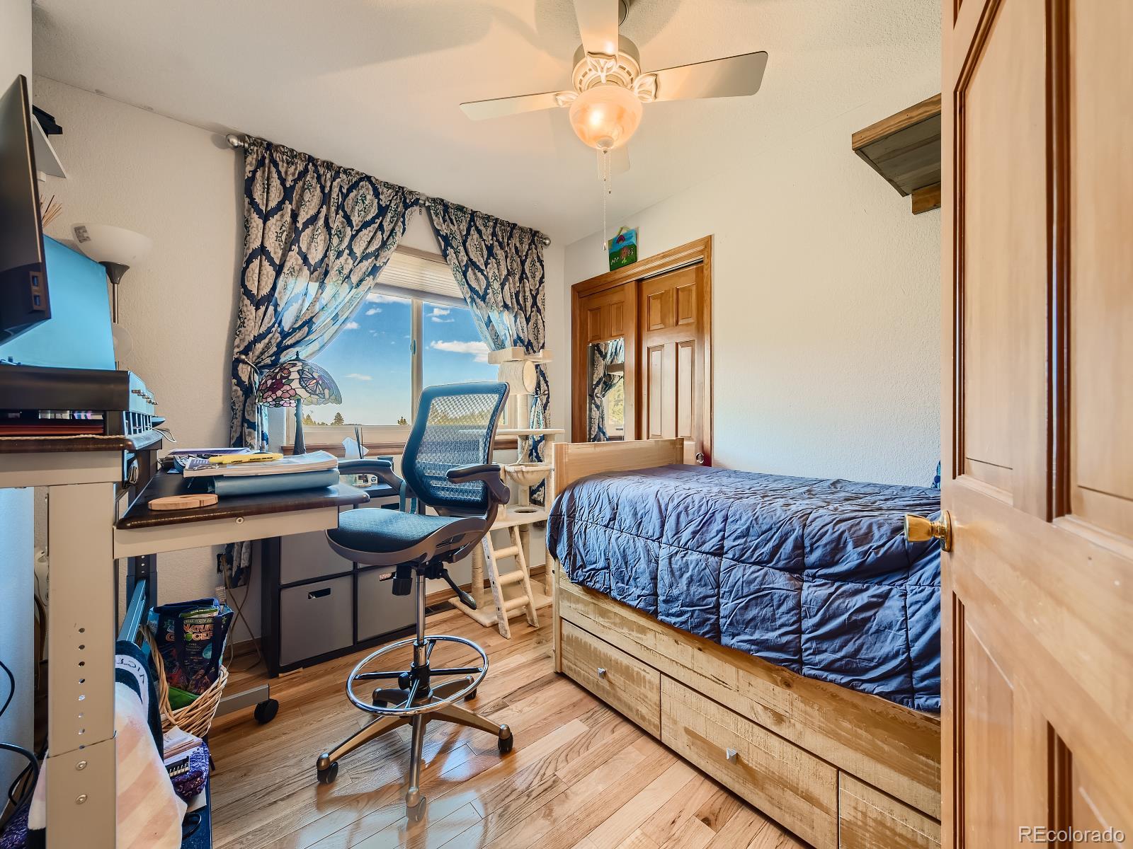 7051 Ski Trail Evergreen, CO 80439 - Photo 14 of 39 a bedroom with a bed and a chandelier