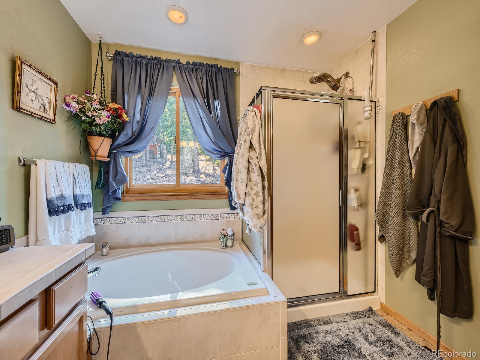 7051 Ski Trail Evergreen, CO 80439 - Photo 17 of 39 a bathroom with a tub a sink and a shower