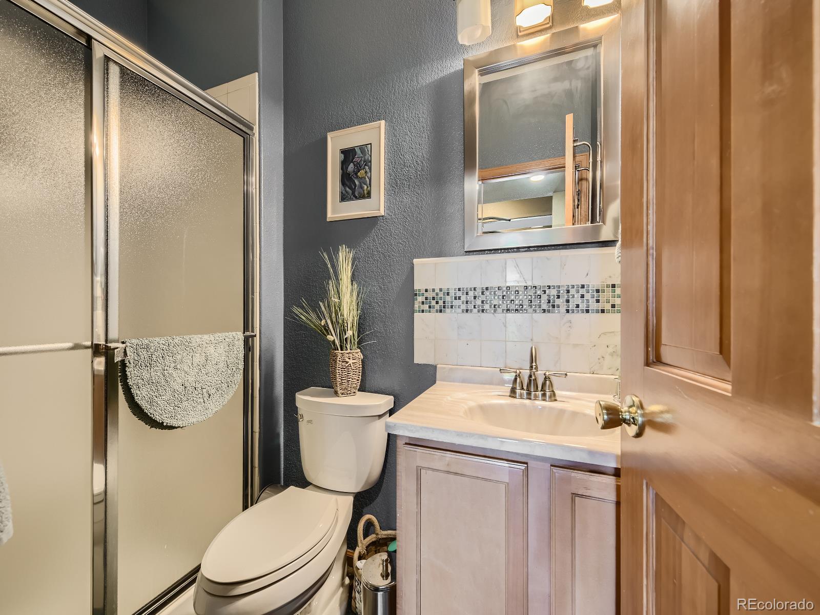 7051 Ski Trail Evergreen, CO 80439 - Photo 21 of 39 a bathroom with a toilet a sink and a mirror