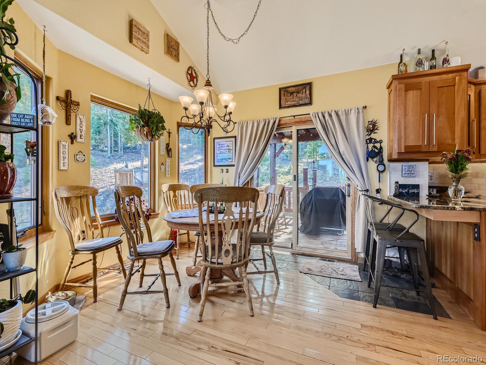 7051 Ski Trail Evergreen, CO 80439 - Photo 4 of 39 a view of a dining room with furniture wooden floor and chandelier