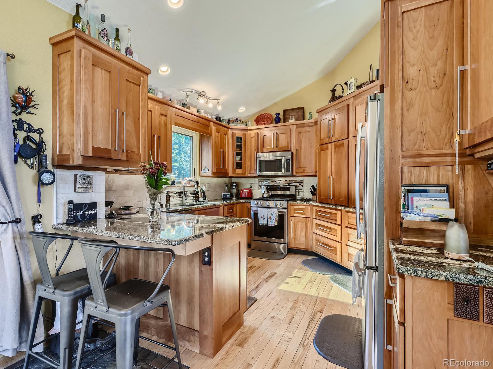 7051 Ski Trail Evergreen, CO 80439 - Photo 9 of 39 a kitchen with kitchen island granite countertop a stove refrigerator dining table and chairs