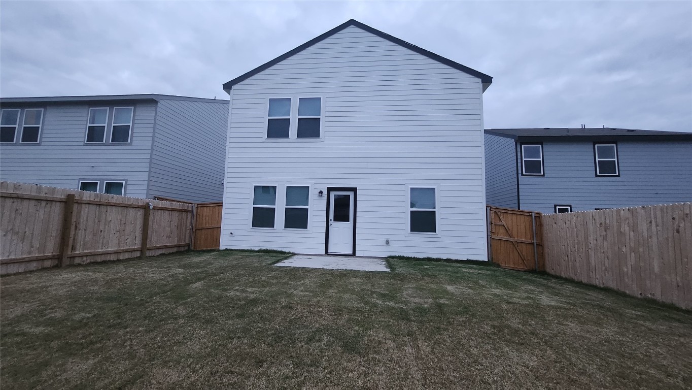 384 Enforcer Loop Jarrell, TX 76537 - Photo 14 of 15 Back of house with a patio area, a fenced backyard, and a gate