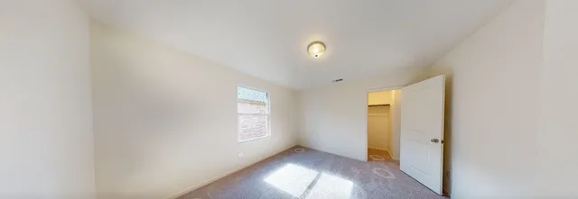 an empty room with windows and closet