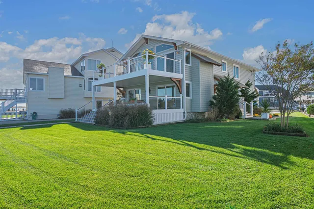 a view of a house with a wooden deck and a yard