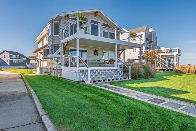 a front view of a house with a yard and outdoor seating