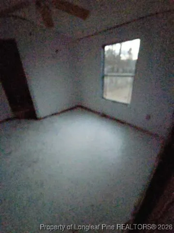 an empty room with windows and fireplace