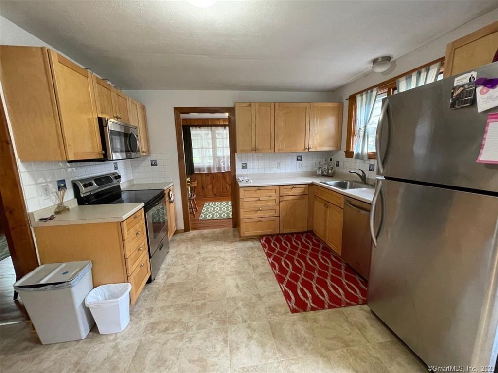 68 Kelsey Place Madison, CT 06443 - Photo 6 of 18 a kitchen with a sink a refrigerator a stove a microwave and island