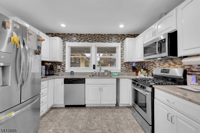 30 General Lane Willingboro, NJ 08046 - Photo 13 of 22 a kitchen with stainless steel appliances granite countertop a stove a sink and a refrigerator