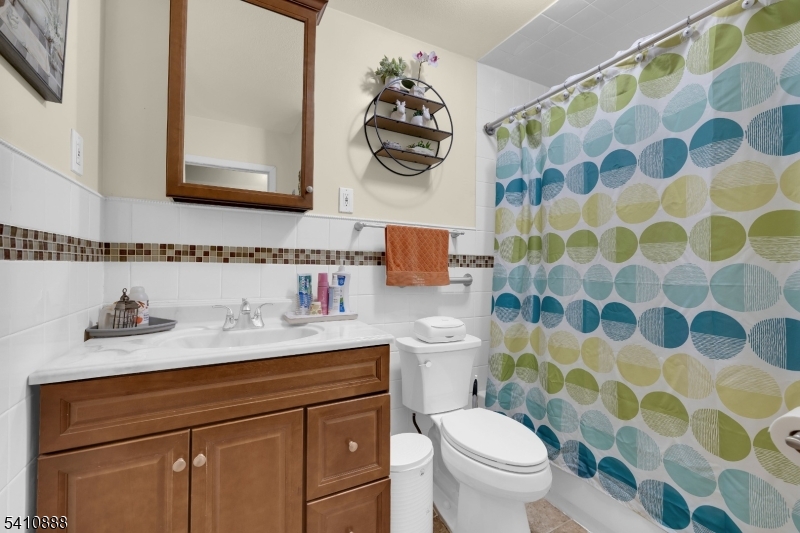 30 General Lane Willingboro, NJ 08046 - Photo 21 of 22 a bathroom with a sink a toilet a mirror and shower curtain