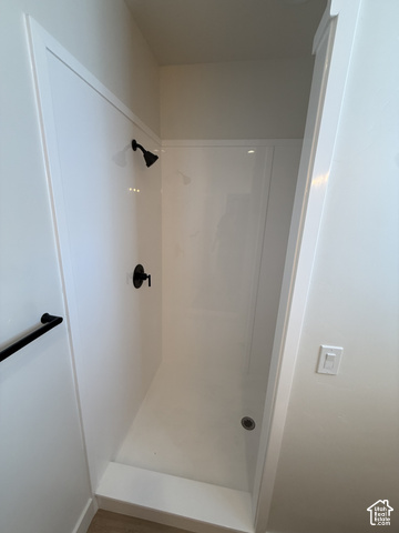 658 West 500 South, Unit 2 Logan, UT 84321 - Photo 12 of 18 Shower enclosure featuring white paneling, matte black shower head, matte black controls, and a built-in shower pan