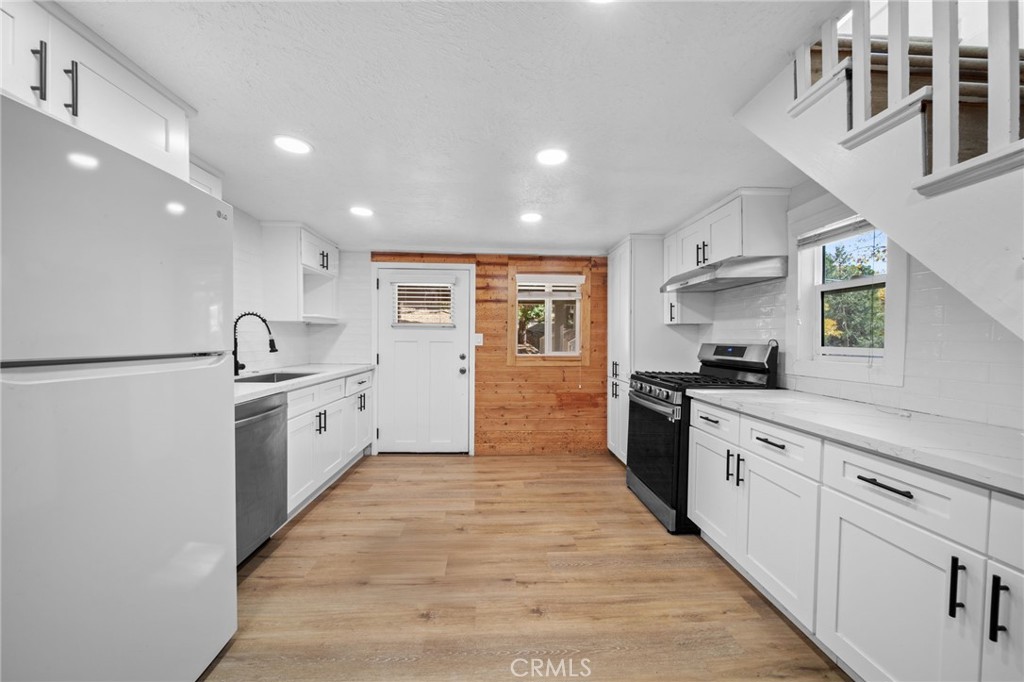 180 Glen Avon Drive Cedar Glen, CA 92321 - Photo 6 of 24 a large white kitchen with stainless steel appliances granite countertop a sink and cabinets