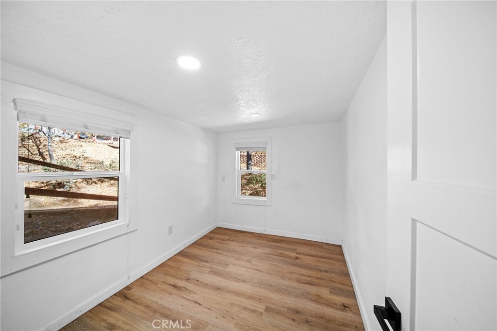 180 Glen Avon Drive Cedar Glen, CA 92321 - Photo 10 of 24 an empty room with wooden floor and window