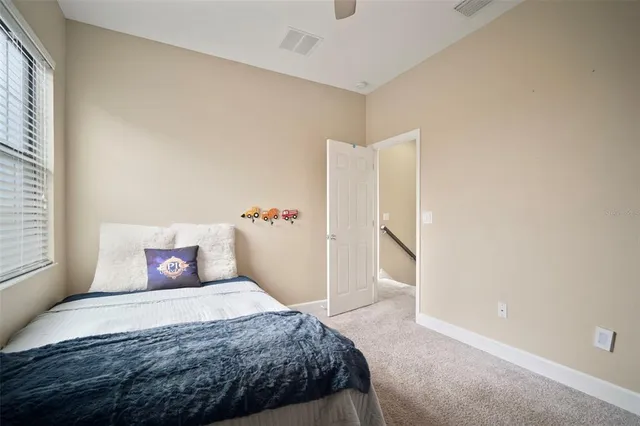 a bedroom with a large bed and wooden floor