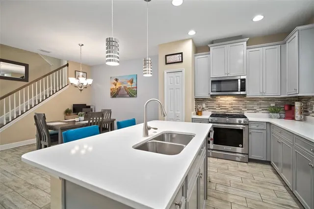 a kitchen with a sink a stove and white cabinets