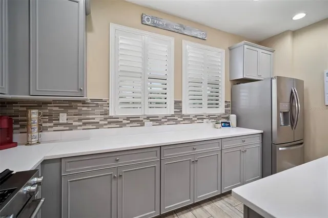 a kitchen with stainless steel appliances granite countertop a sink a refrigerator and a stove