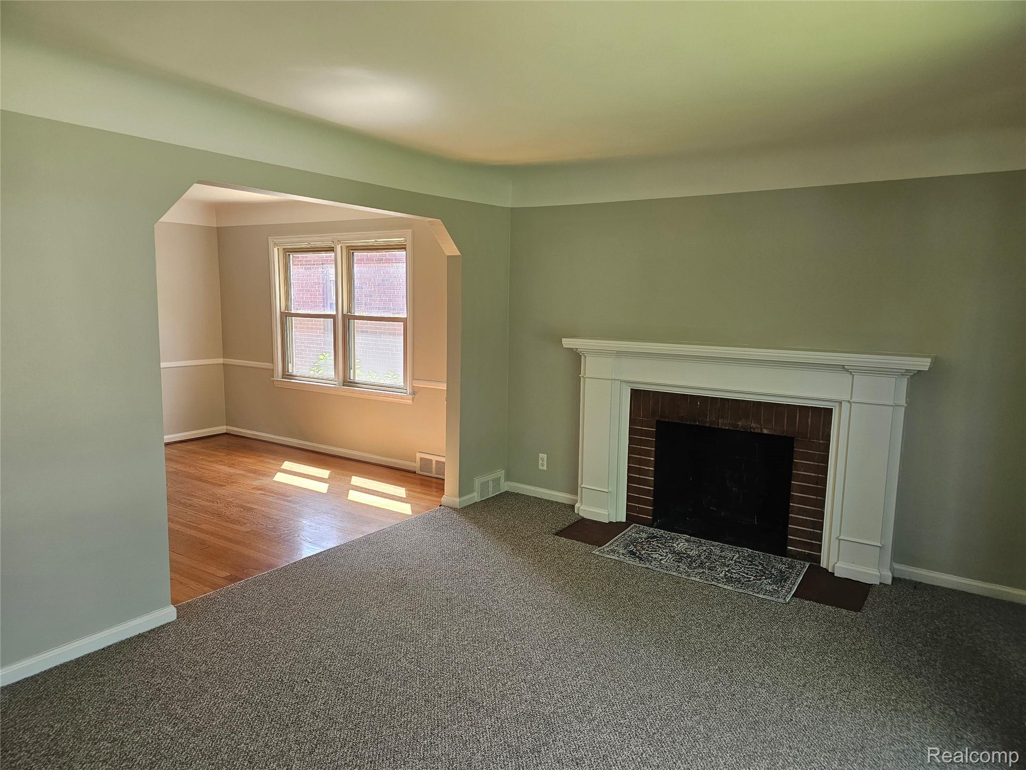 5240 Harvard Road Detroit, MI 48224 - Photo 6 of 18 Living area featuring a classic fireplace with a white mantel and brick surround