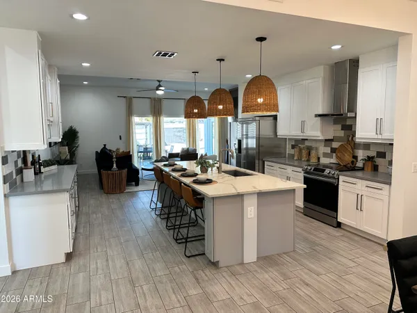 a kitchen with stainless steel appliances granite countertop a sink a stove and a dining table with wooden floor