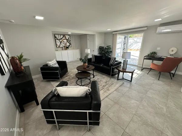a living room with patio furniture and a potted plant