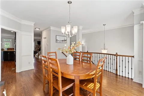 a view of a dining room and livingroom with furniture wooden floor a chandelier