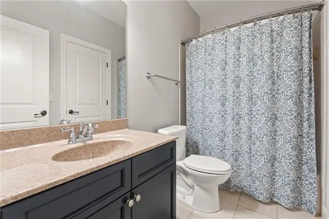 a bathroom with a granite countertop sink a toilet and a mirror