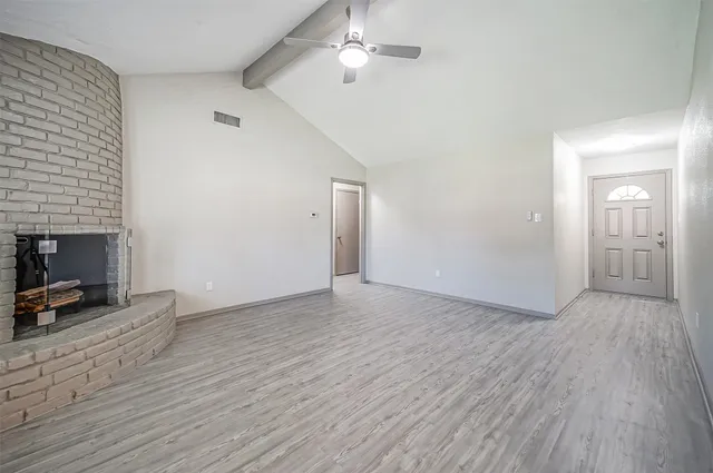 wooden floor in an empty room with a fireplace