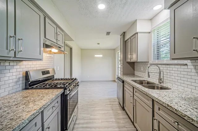 a kitchen that has a sink and a stove
