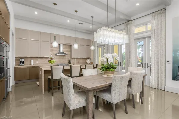 a view of a dining room and livingroom with furniture wooden floor a chandelier