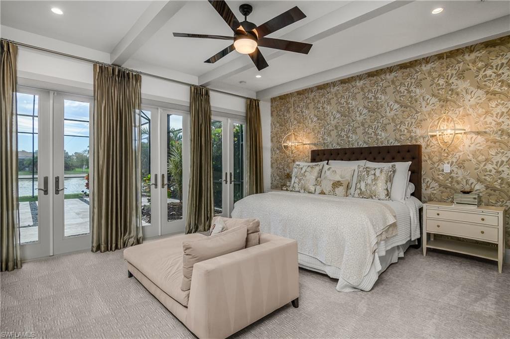 14852 Dockside Lane Naples, FL 34114 - Photo 12 of 49 a bedroom with a large bed and a chandelier fan