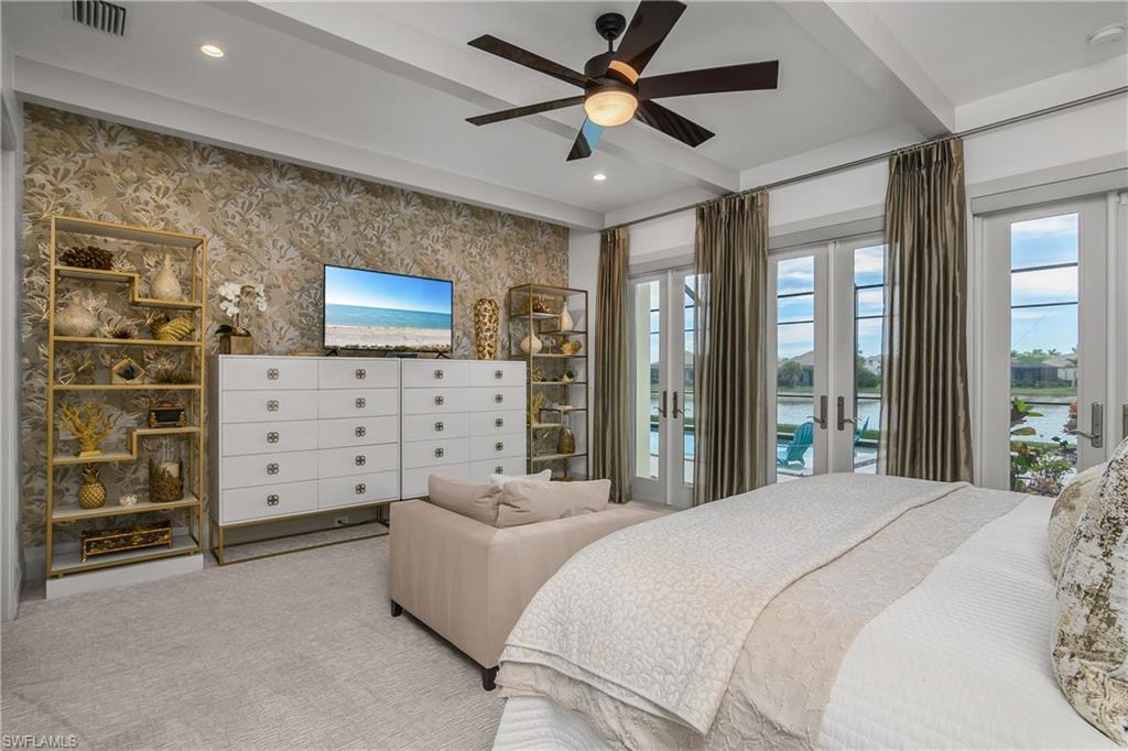 14852 Dockside Lane Naples, FL 34114 - Photo 13 of 49 a spacious bedroom with a bed and a television