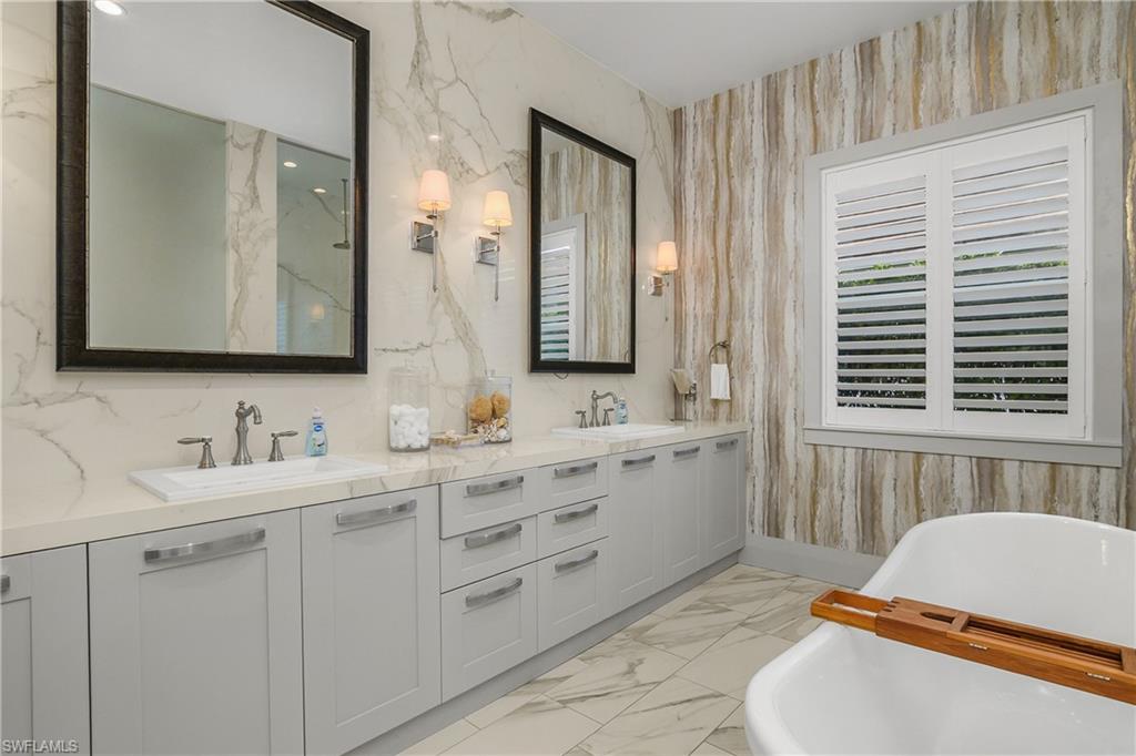 14852 Dockside Lane Naples, FL 34114 - Photo 14 of 49 a bathroom with a sink mirror and a bathtub