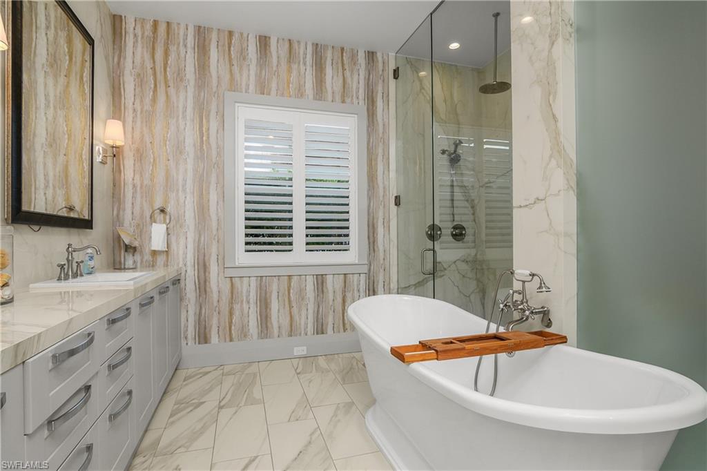 14852 Dockside Lane Naples, FL 34114 - Photo 16 of 49 a bathroom with a tub a sink and a shower