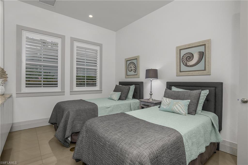 14852 Dockside Lane Naples, FL 34114 - Photo 21 of 49 a bedroom with two beds and a window