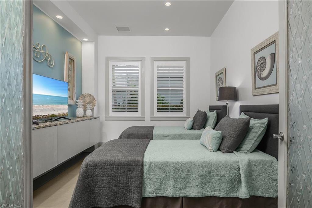14852 Dockside Lane Naples, FL 34114 - Photo 22 of 49 a bedroom with a bed and dresser with mirror