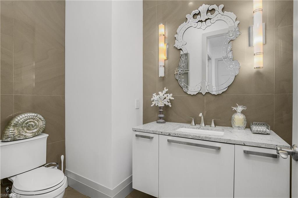 14852 Dockside Lane Naples, FL 34114 - Photo 23 of 49 a bathroom with a sink vanity mirror and toilet