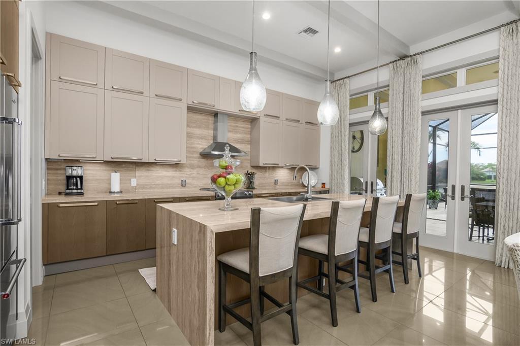 14852 Dockside Lane Naples, FL 34114 - Photo 3 of 49 a kitchen with a table chairs refrigerator and cabinets