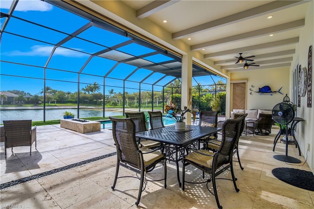 14852 Dockside Lane Naples, FL 34114 - Photo 31 of 49 a view of a patio with a dining table and chairs under an umbrella