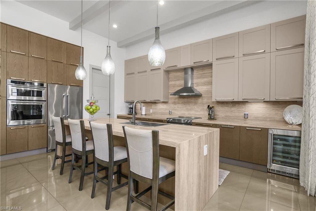 14852 Dockside Lane Naples, FL 34114 - Photo 4 of 49 a kitchen with kitchen island granite countertop a sink a center island and appliances