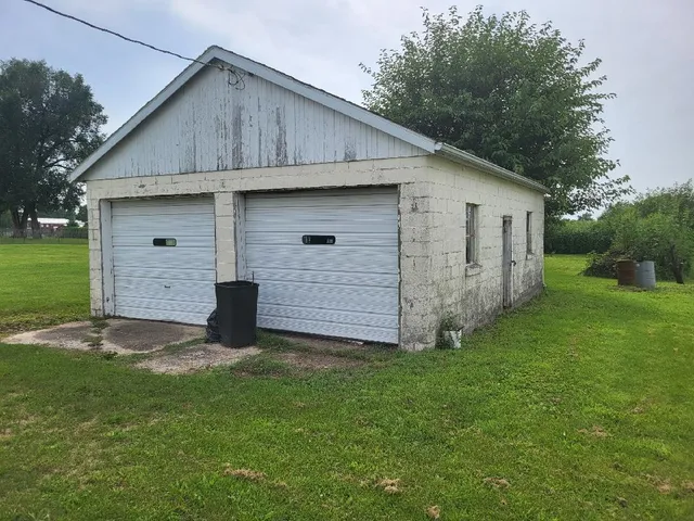 a view of a backyard with brick wall and a large tree