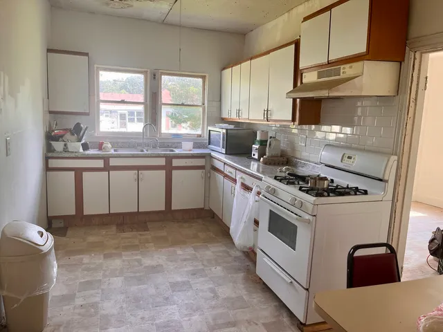 a kitchen with stainless steel appliances a sink stove and cabinets