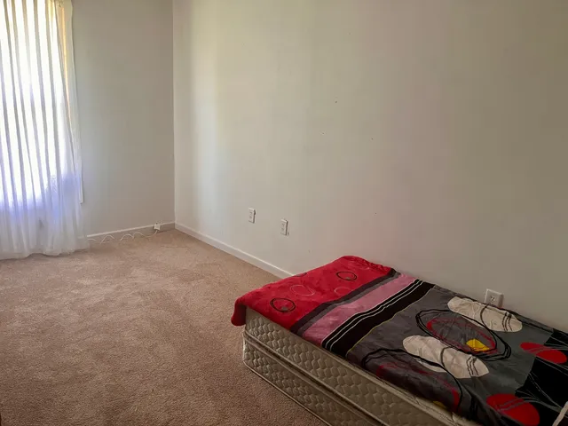 a living room with a bed and a window