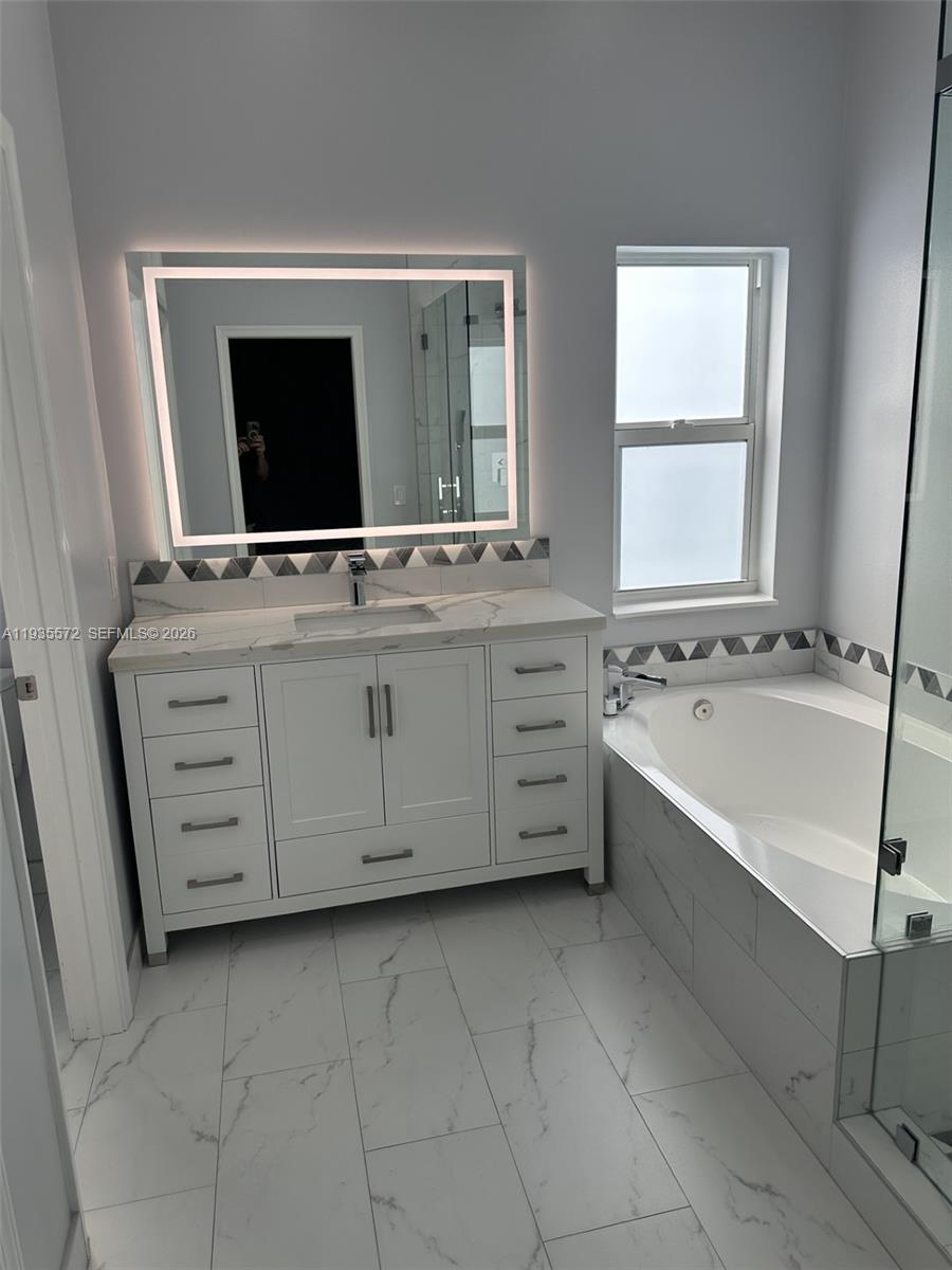 The Ridges Weston, FL 33331 - Photo 15 of 28 a bathroom with a double vanity sink a mirror and bathtub