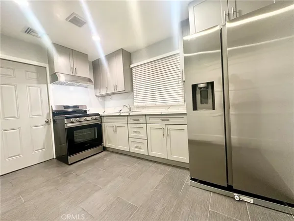 a kitchen with stainless steel appliances cabinets a sink and a refrigerator