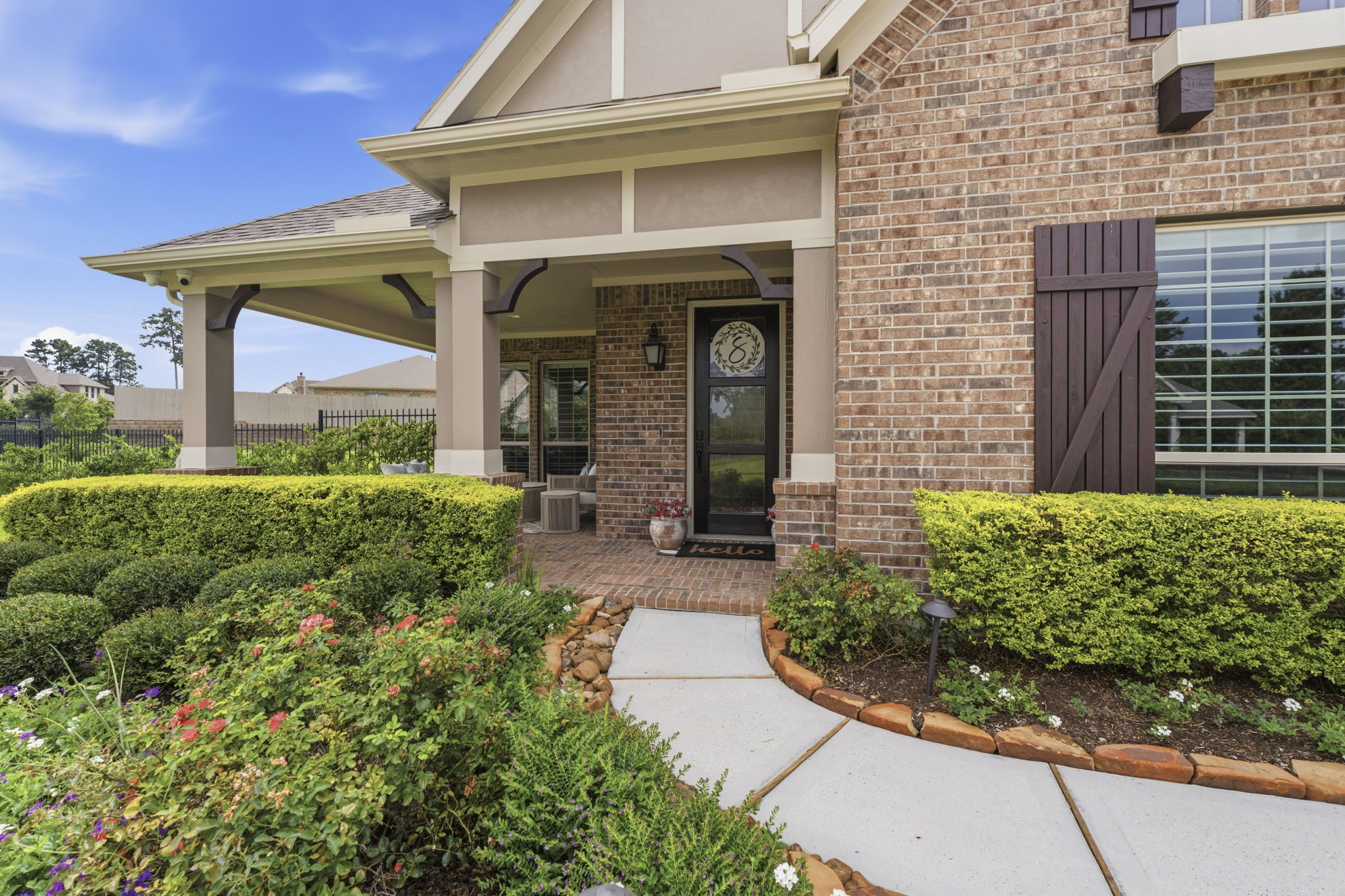 14012 Beartooth Bend Trail Conroe, TX 77384 - Photo 5 of 50 From the moment you arrive, the home’s impeccable curb appeal makes a lasting impression, featuring lush landscaping, elegant exterior lighting, charming wood shutters, and coach lights. A timeless mahogany and glass front door serves as a stunning focal point.