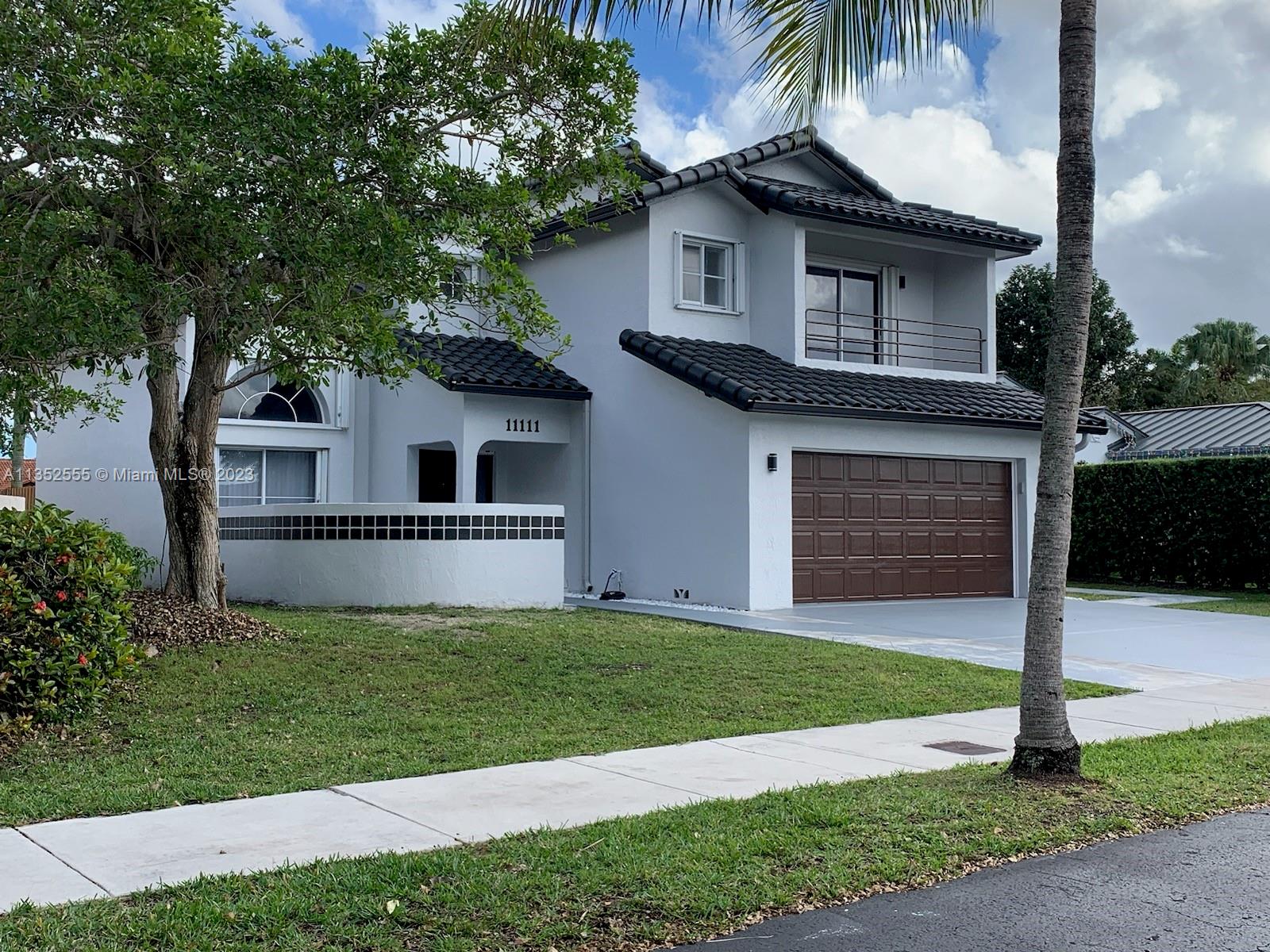 11111 Southwest 147th Court Miami, FL 33196 - Photo 1 of 20 a front view of a house with a yard and garage