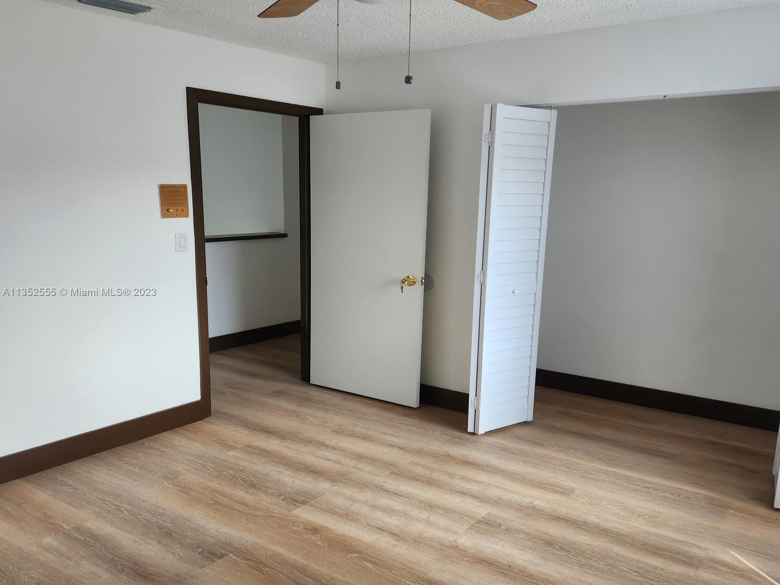 11111 Southwest 147th Court Miami, FL 33196 - Photo 14 of 20 a view of an empty room with wooden floor and a refrigerator